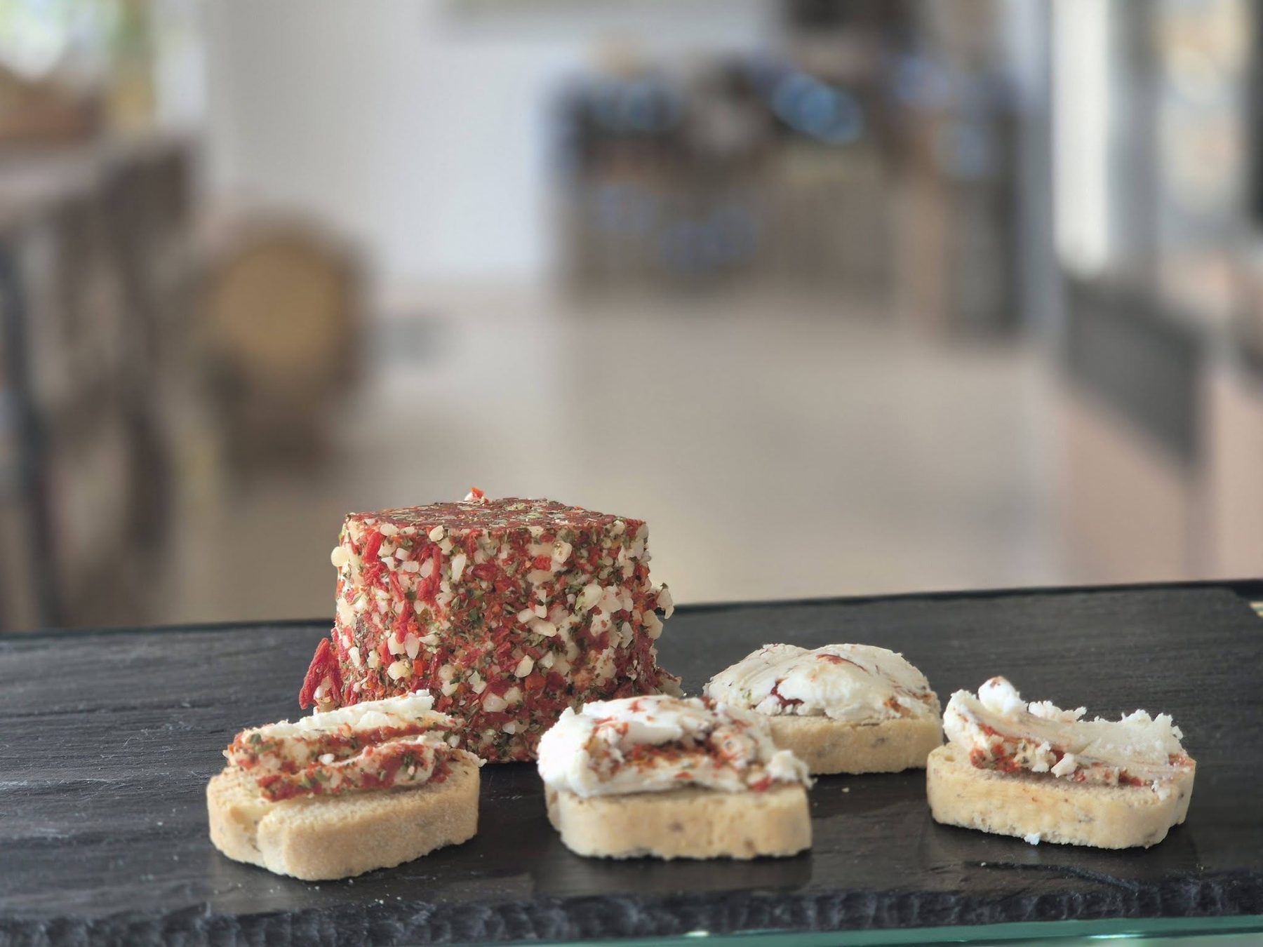Toasts garnis d'une spécialité au fromage de chèvre aux poivres, sur ardoise