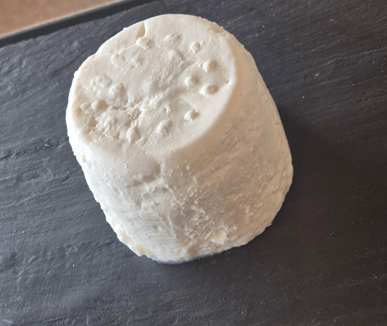 Fromage de chèvre frais nature présenté sur une ardoise
