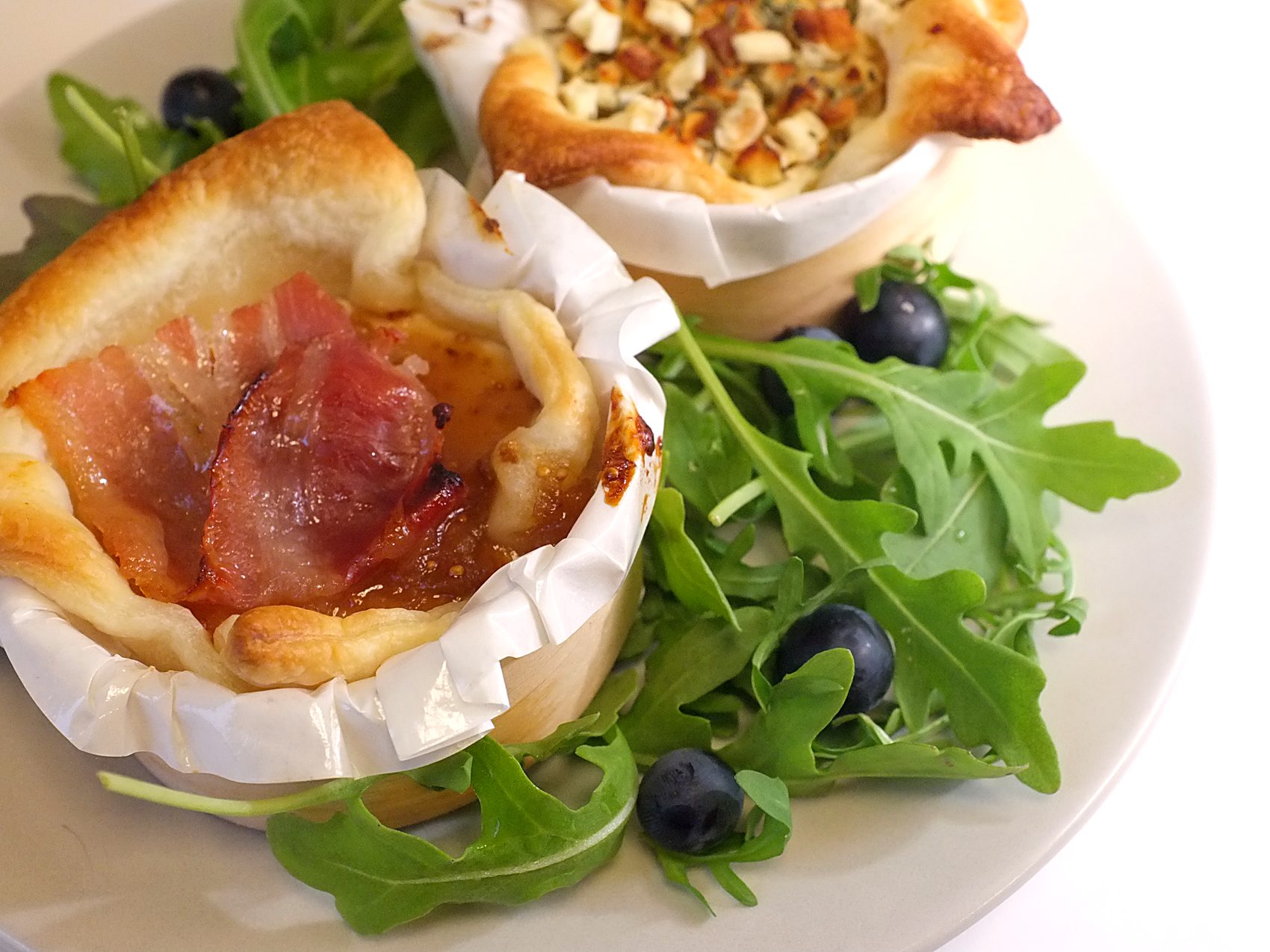 Tartelette feuilletée au fromage de chèvre chaud et lard, sur roquette et myrtilles, une spécialité de la Fromagerie du Pont de Pierre